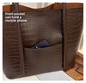 Detail of front pocket on brown crocodile embossed tote bag fitting a large smartphone
