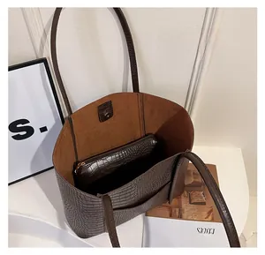 Detail of dark brown croc-effect tote bag showing spacious interior with matching zipper pouch
