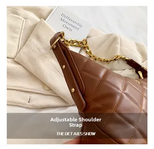 Detail of adjustable golden chain strap and quilted brown faux leather on a luxury handbag