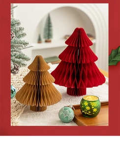 Detail of red and brown paper honeycomb Christmas trees with a festive glass candle holder