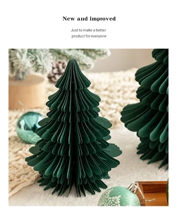 Detailed view of a dark green paper honeycomb Christmas tree on a soft white faux fur rug