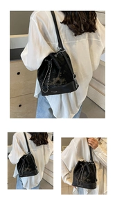 Detail view of the velvet and leather bucket bag with silver chain and brand logo