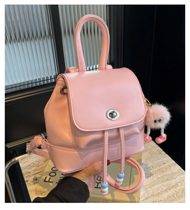 Dettaglio mini zaino rosa con chiusura a coulisse e ciondolo mostro di peluche