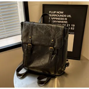 Detail eines schwarzen Vintage-Rucksacks mit Klappe und goldenen Metallschnallen