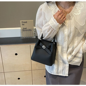 Detail einer schwarzen Eimer-Tasche aus Leder mit einzigartigem Schleifen-Drehverschluss