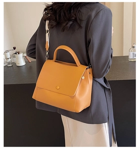 Details einer Vintage-gelben Handtasche mit gemustertem, breitem gewebtem Schultergurt