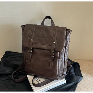 Detail eines dunkelbraunen Vintage-Rucksacks aus Kunstleder mit Retro-Schnallen und Textur