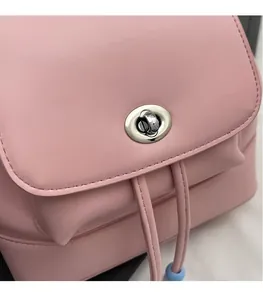 Dettaglio di zaino rosa in similpelle con chiusura a scatto argentata e coulisse