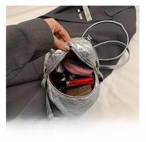 Detail view of mini silver quilted backpack interior showing space for phone and wallet