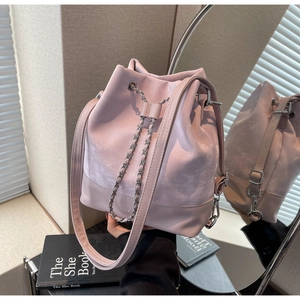Pink bucket bag with chain drawstring and lychee pattern leather shown in a mirror reflection
