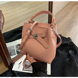 Detailansicht der rosa Lederstruktur mit Litschi-Muster und Metalldrehverschluss der Tasche