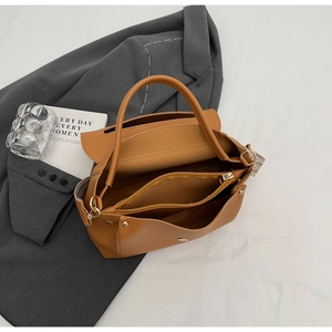 Innenansicht der braunen PU-Ledertasche mit mehreren Fächern und gemustertem Schultergurt