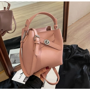 Nahaufnahme der rosa Eimer-Tasche mit Lychee-Muster, silbernem Schloss und Riemen