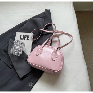 Detailansicht der rosa glänzenden Muscheltasche mit silbernen Metallteilen und Riemen