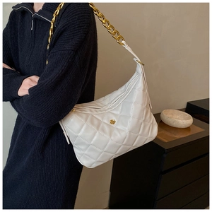 Close-up of white quilted hobo bag with gold rose clasp and chunky chain strap detail