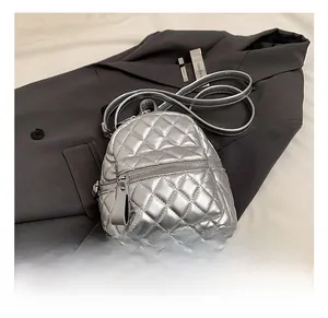 Detail of silver quilted mini backpack with metallic finish on dark grey blazer