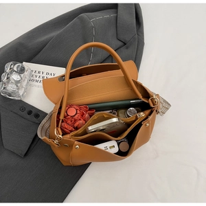 Innenansicht mit großem Stauraum und gemustertem Gurt für braune Handtasche