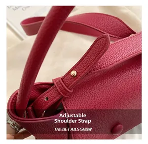 Close-up of rose red litchi texture bag showing adjustable strap with gold buckle detail
