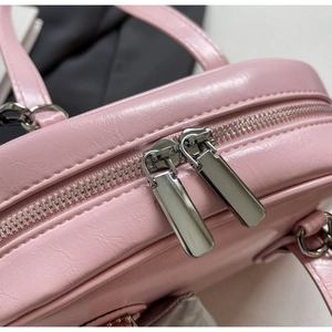 Detail der rosafarbenen Shell-Tasche aus Kunstleder mit silbernem Doppelreißverschluss