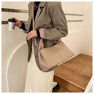 Detailansicht der beigefarbenen PU-Leder Tragetasche getragen von einem Modell im urbanen Stil