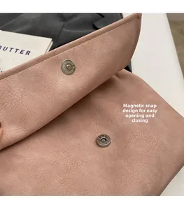 Detail of the magnetic buckle closure on a dusty pink suede texture tote bag