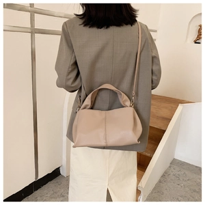 Khaki gefaltete PU-Tasche kombiniert mit grauem Blazer für einen minimalistischen Look