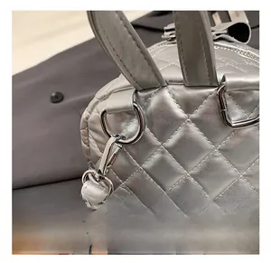 Detail shot of the silver metal hook and quilted texture on a stylish backpack