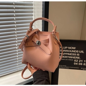 Detailansicht der rosa Eimer-Tasche aus Leder mit silbernem Drehverschluss und Riemen
