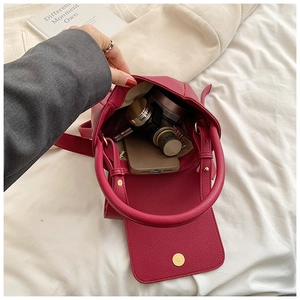 Detail showing spacious interior of rose red lychee grain bucket bag with magnetic closure