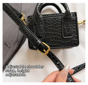Close-up of adjustable strap buckle and gold hardware on black crocodile pattern bag