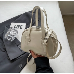 Detailaufnahme der cremefarbenen Leder-Muschel-Handtasche mit silbernen Metallakzenten