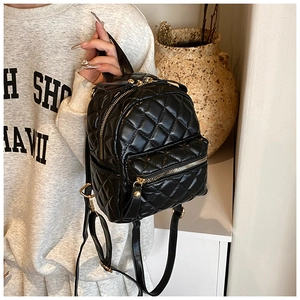 Mini black quilted backpack with gold zippers shown on a person for a stylish look