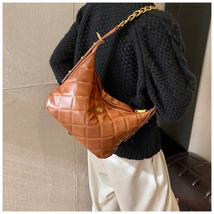 Detail of brown quilted half-moon bag with gold chain strap and vintage hardware