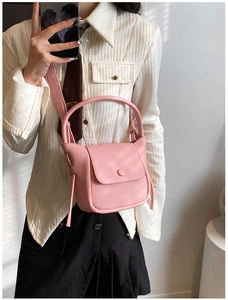 Close-up of pink litchi pattern leather bag with flap closure and wide shoulder strap