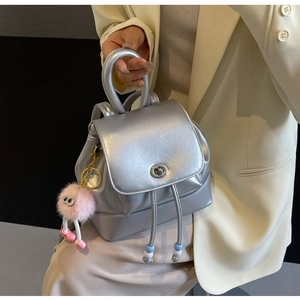 Dettaglio mini zaino argento metallizzato con coulisse di perle e ciondolo di peluche