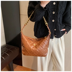 Detail of the large quilted hobo bag featuring golden flower logo and chain strap