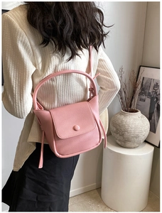 Pink lychee texture crossbody bag shown on a model in a minimalist lifestyle indoor setting