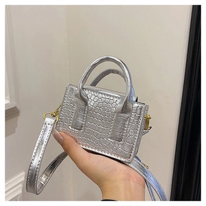 Detail of silver crocodile-embossed mini handbag with metallic handles and strap