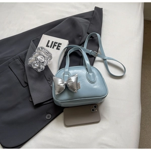 Kleine hellblaue Muscheltasche mit silbernem Schleifenanhänger und Schultergurt