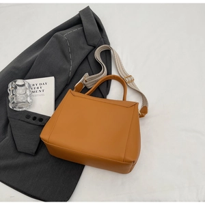 Detail der warmen braunen Lederhandtasche mit geometrischem Riemen und schlichtem Design