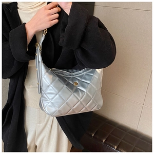 Detail of silver quilted handbag with golden rose clasp and leather chain strap