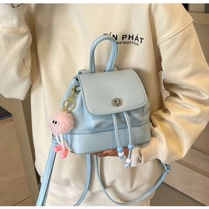 Dettaglio mini zaino celeste con chiusura a girello e ciondolo in peluche rosa