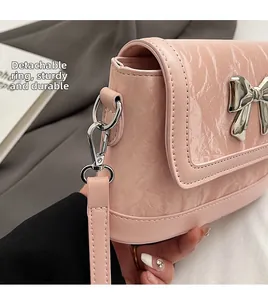Detail of pink stone-textured handbag featuring silver butterfly and detachable metal buckle