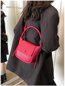 Detail shot of the lychee texture leather on the red crossbody bag with top handle