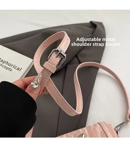 Detail of pink bucket bag showing silver metal hardware buckle and adjustable leather strap
