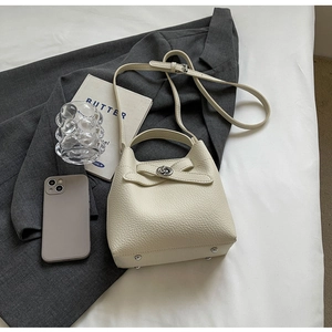 Detailansicht der cremefarbenen Bucket Bag aus Leder mit Kieselstruktur und Metallteilen