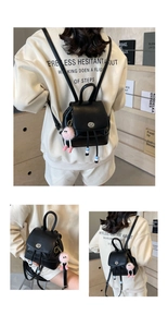 Dettaglio mini zaino in pelle PU nera con chiusura a rotazione e ciondolo di peluche