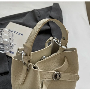 Detailansicht der cremeweißen Beuteltasche aus Leder mit Narbung und Silberverschluss