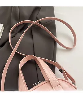 Détail du sac à bandoulière rose avec ferrures argentées, poignée et sangle confortable