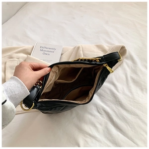 Interior view of quilted crossbody bag with multiple compartments and gold hardware detail